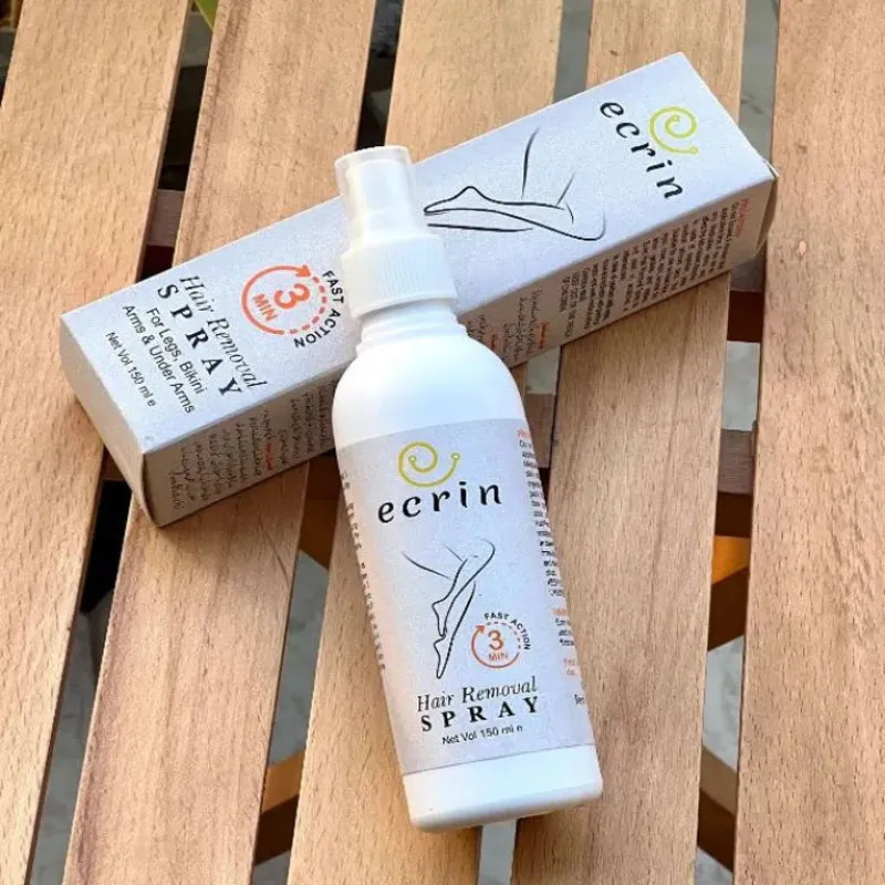 Ecrin hair removal spray bottle displayed beside its packaging on a wooden surface